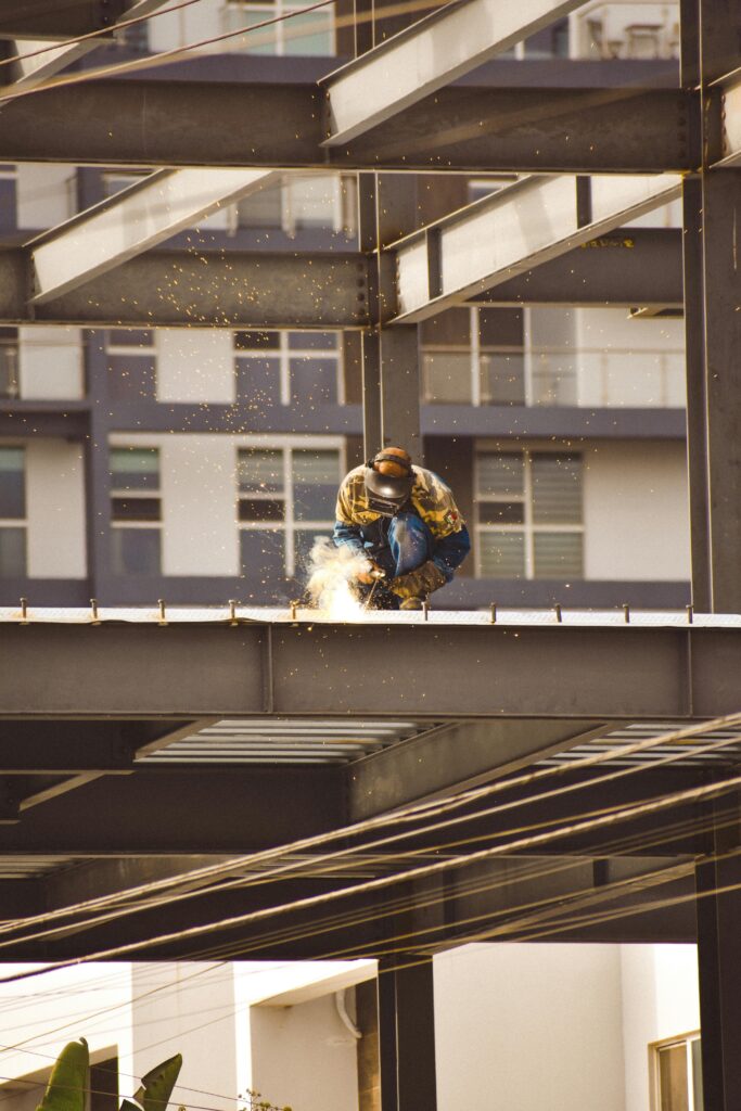 A skilled welder working on a steel structure during a bright day in Tijuana.